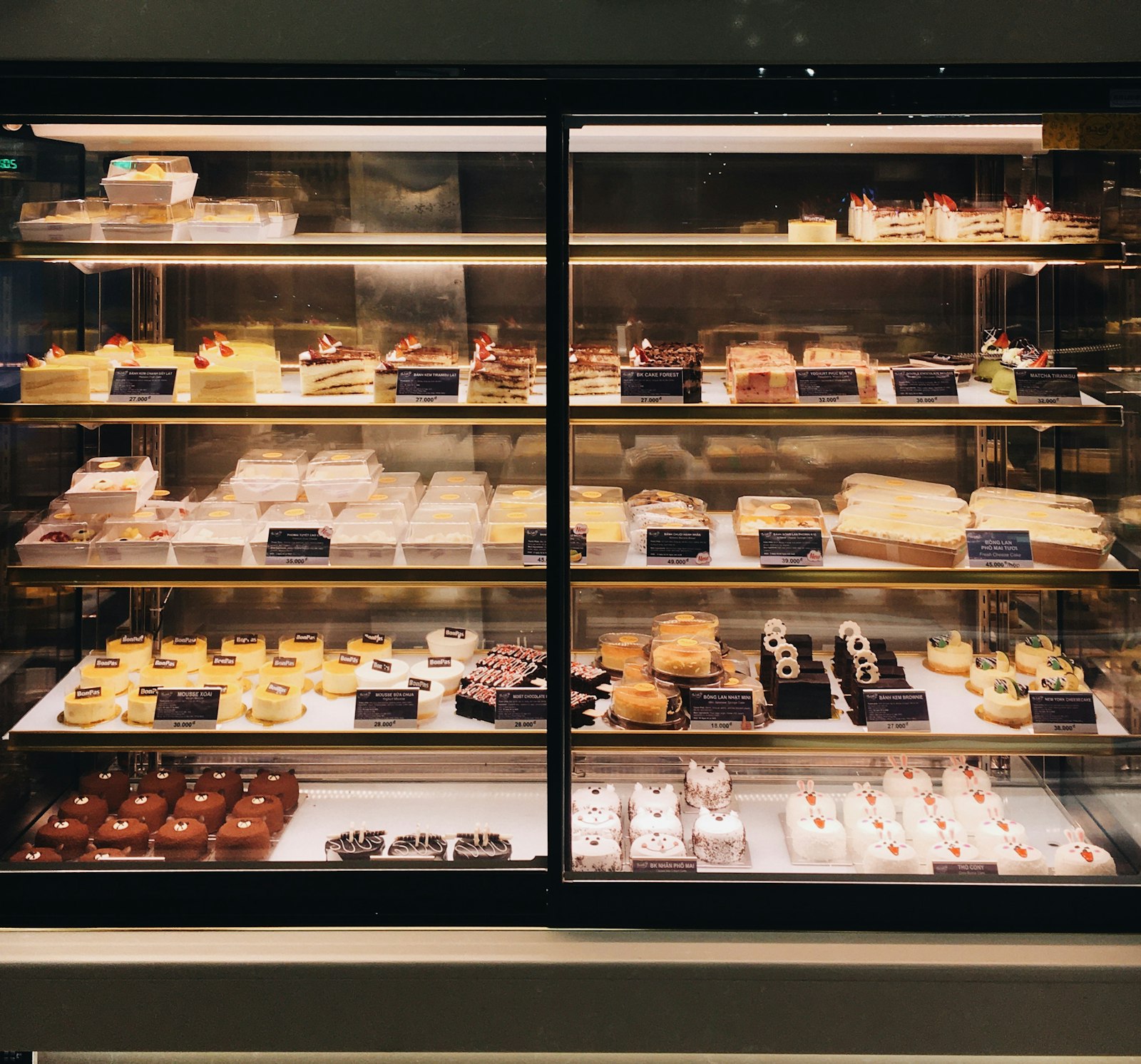 A bakery display case filled with cakes and pastries