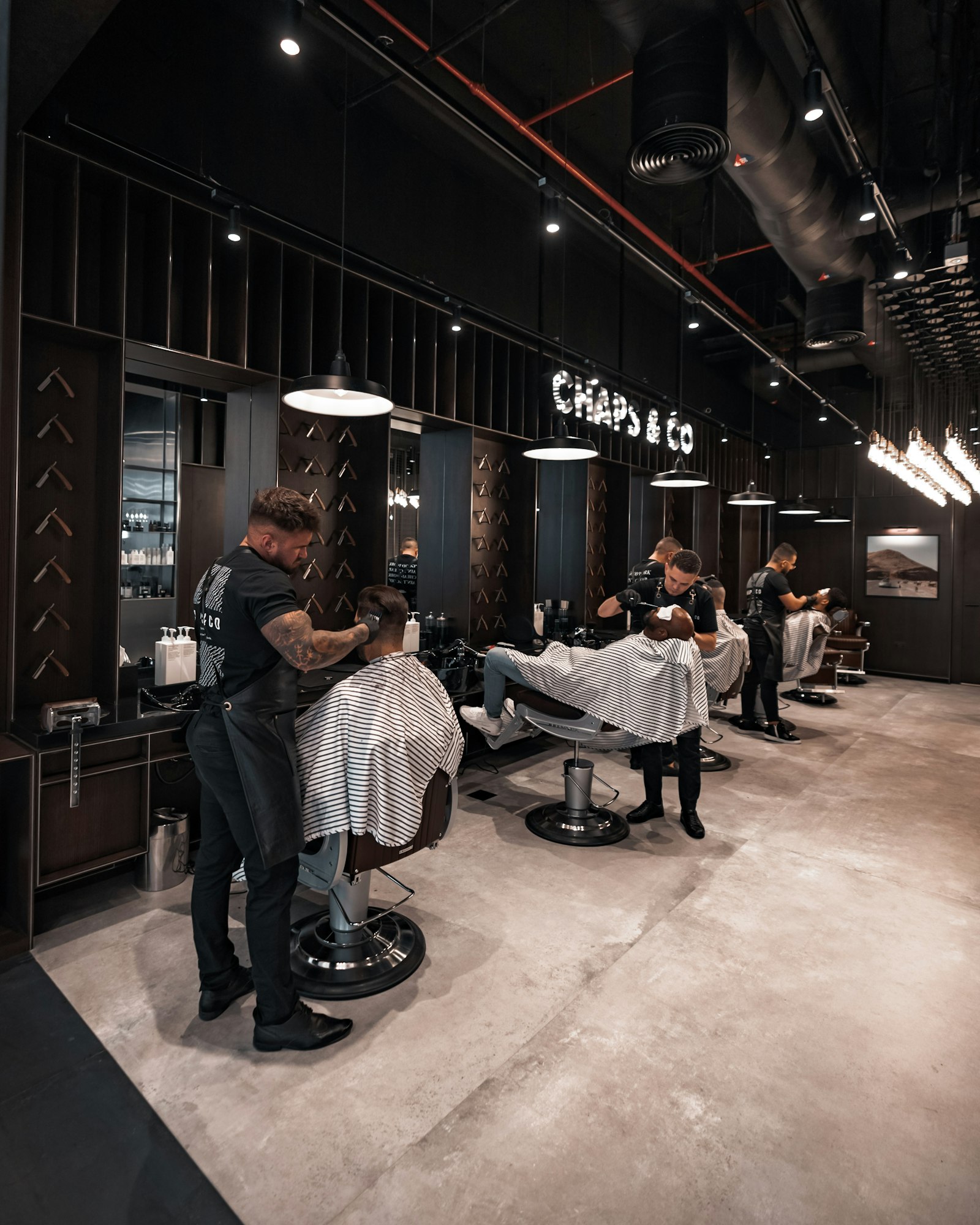 Barbers cutting hair in a busy neighborhood barbershop