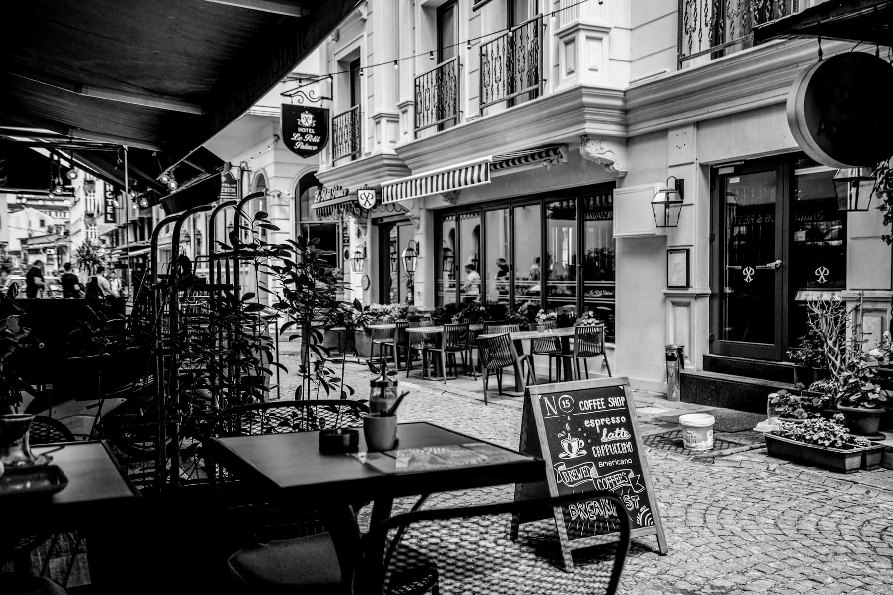 A café storefront on a cobbled street with a chalkboard sign out front, the kind of local business Emelyne Studio works with